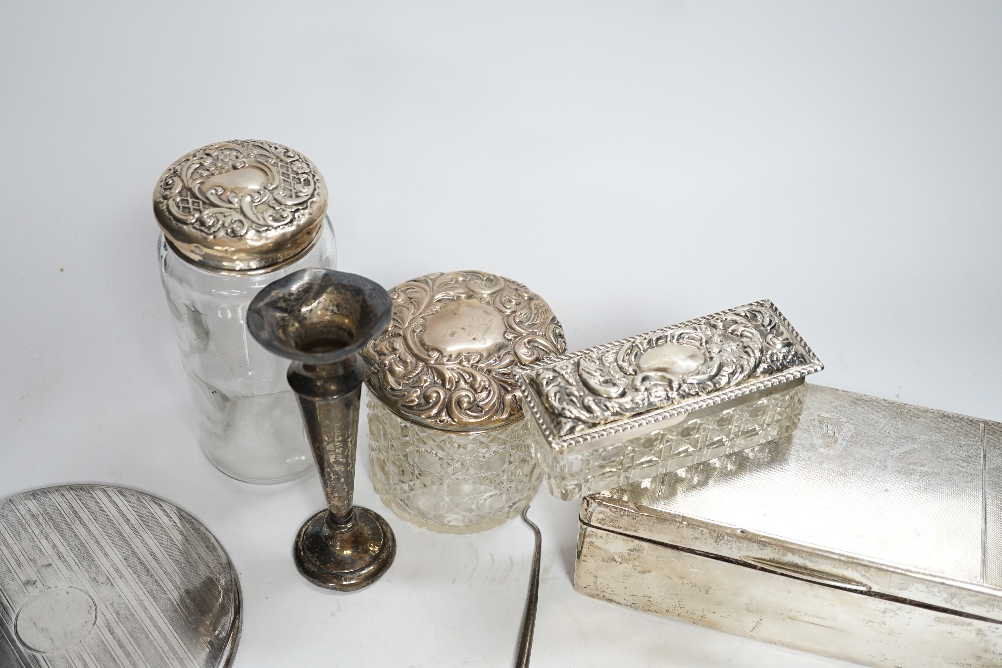 Sundry small silver including a silver mounted cigarette box, four assorted mounted glass toilet jars, a vesta case, button hook, hand mirror and trumpet vase.